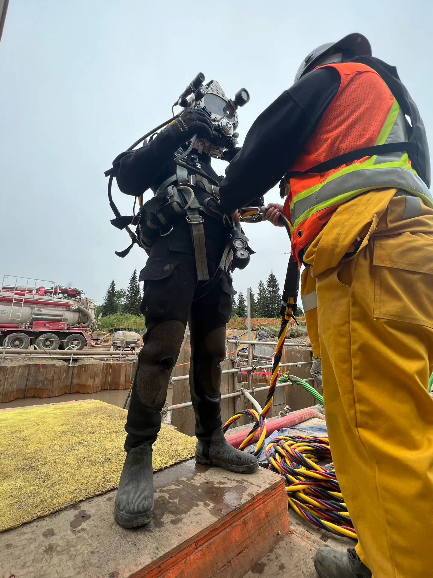 Commercial diver and surface team verifying cathodic protection field work