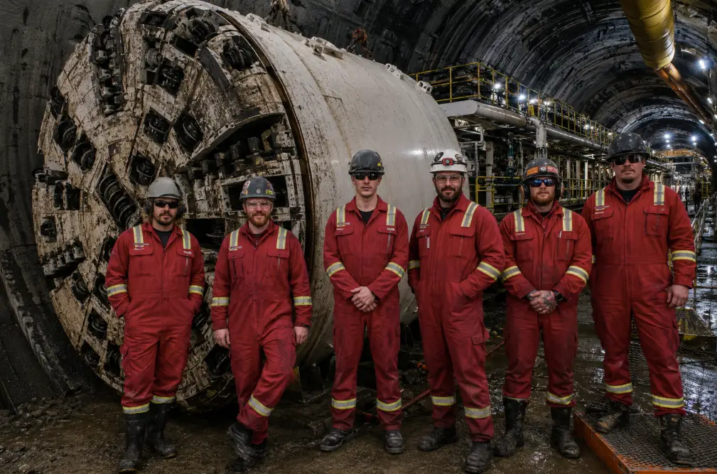 Hyperbaric Tunneling Support team assembled in front of a tunnel boring machine